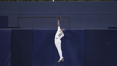 Melvin Upton Jr. of the San Diego Padres goes over the wall to take away a home run from J.J. Hardy #2 of the Baltimore Orioles. (Photo by Denis Poroy/Getty Images)