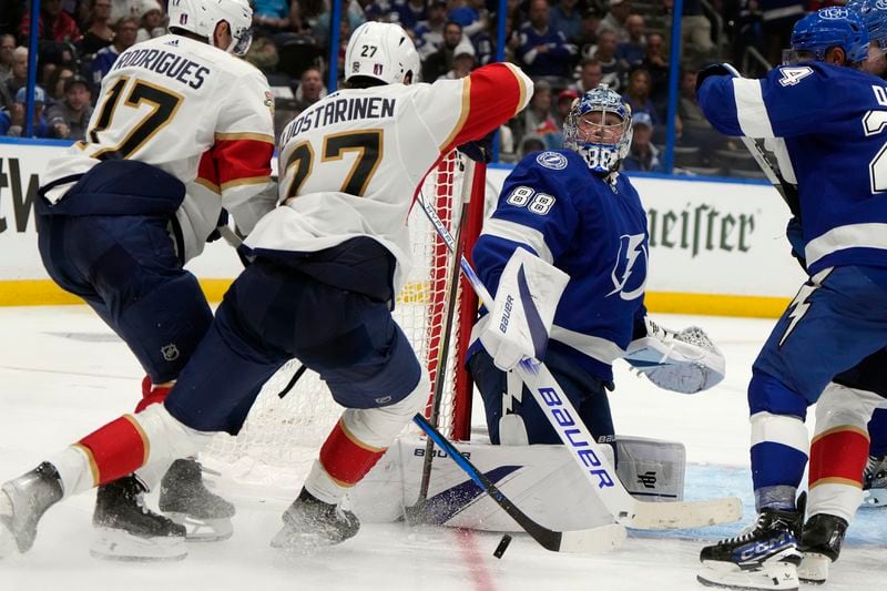 Tampa Bay Lightning goaltender Andrei Vasilevskiy (88) stops a shot by Florida Panthers center Evan Rodrigues (17) and center Eetu Luostarinen (27) during the third period in Game 3 of an NHL hockey Stanley Cup first-round playoff series, Thursday, April 25, 2024, in Tampa, Fla. (AP Photo/Chris O'Meara)