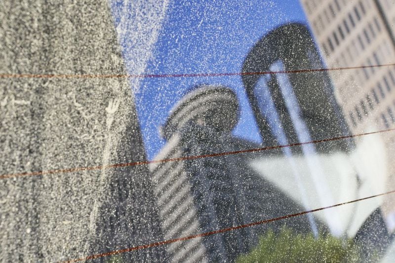 A parked car at John Portman Blvd. and Peachtree Center Avenue reflects a pollinated view of the Atlanta skyline from the back window in April 2013. JOHN SPINK / JSPINK@AJC.COM
