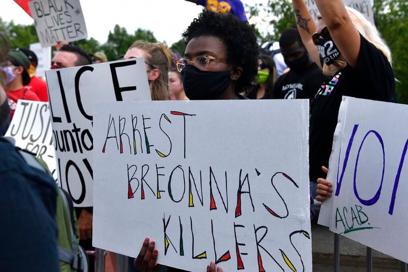 A woman holds up a sign during a rally in memory of Breonna Taylor on the steps of the Kentucky State Capitol in Frankfort, Ky., Thursday, June 25, 2020. The rally was held to demand justice in the death of Taylor who was killed in her apartment by members of the Louisville Metro Police Department on March 13, 2020. (AP Photo/Timothy D. Easley)