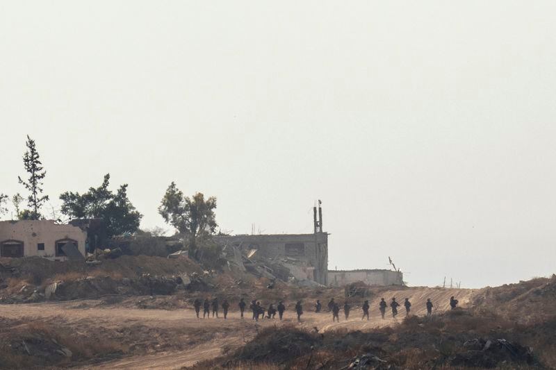 Israeli troops walk in the Gaza Strip, seen from southern Israel, Wednesday, May 1, 2024. (AP Photo/Ohad Zwigenberg)