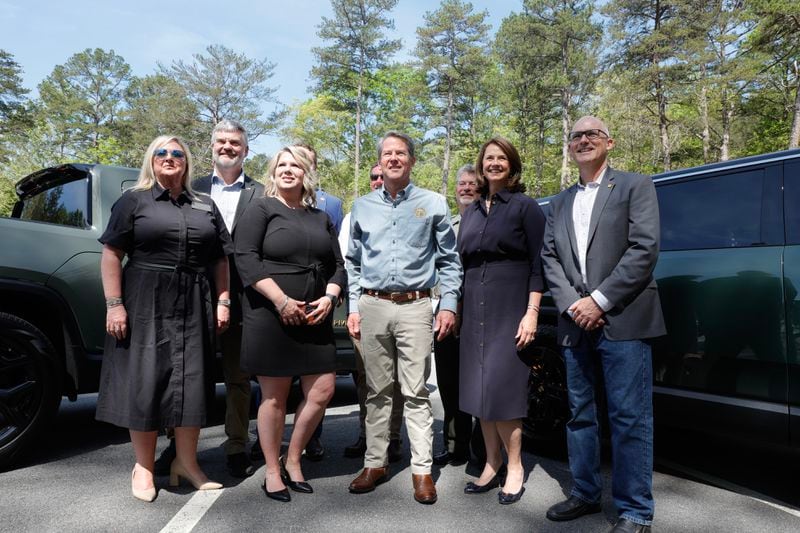 Gov. Brian Kemp takes a photo with Rivian and Department of Natural Resources officials after unveiling the first ever Rivian charging station at Tallulah Gorge State Park on Thursday, April 20, 2023.  (Natrice Miller/natrice.miller@ajc.com)