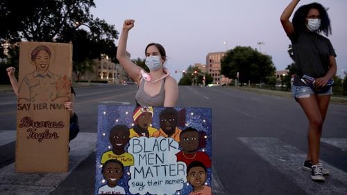 People raise their fists Tuesday, June 23, 2020 in Kansas City, Mo., as they protest the death of Black people, including Breonna Taylor, at the hands of police (AP Photo/Charlie Riedel)