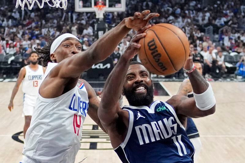 Los Angeles Clippers guard Terance Mann, left, and Dallas Mavericks guard Kyrie Irving reach for rebound during the second half in Game 5 of an NBA basketball first-round playoff series Wednesday, May 1, 2024, in Los Angeles. (AP Photo/Mark J. Terrill)