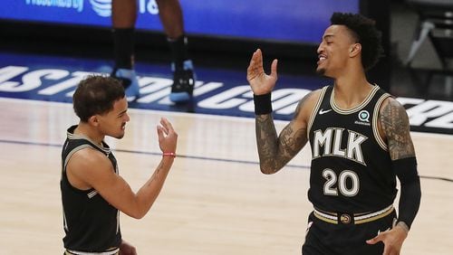 Atlanta Hawks guard Trae Young and forward John Collins get together to begin the game against the Milwaukee Bucks in Game 6 of the NBA Eastern Conference Finals on Saturday, July 3, 2021, in Atlanta.   “Curtis Compton / Curtis.Compton@ajc.com”