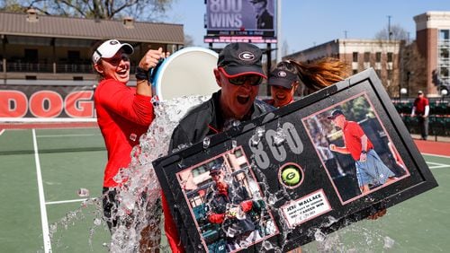 Georgia coach Jeff Wallace gets a surprise water-cooler bath after the Bulldogs won the 800th match of his career as the women's tennis coach against Missouri at Henry Feild Stadium at the Dan Magill Tennis Complex in Athens, on Sunday, March 5, 2023. Wallace, who has since won 14 more matches, announced his retirement Friday after 38 years on the job. (Kayla Renie/UGA Athletics)