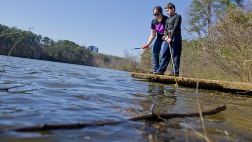 Elisabeth Cortez (left) and her brother Quinn play by the edge of the pond at Murphey Candler Park in Brookhaven in 2014.    JONATHAN PHILLIPS / SPECIAL