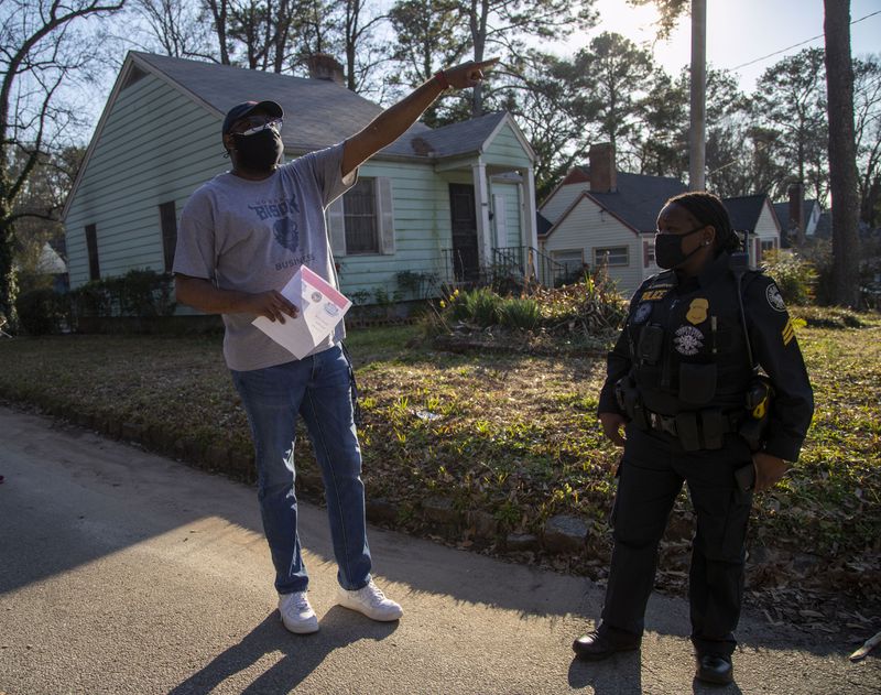 Jason Hudgins (left) passes out flyers in his neighborhood Thursday as authorities search for clues in the fatal shooting of 12-year-old David Mack. 