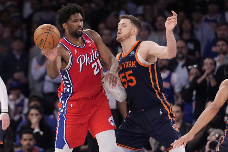 Philadelphia 76ers' Joel Embiid (21) passes the ball away from New York Knicks' Isaiah Hartenstein (55) during the second half of Game 2 in an NBA basketball first-round playoff series Monday, April 22, 2024, in New York. (AP Photo/Frank Franklin II)