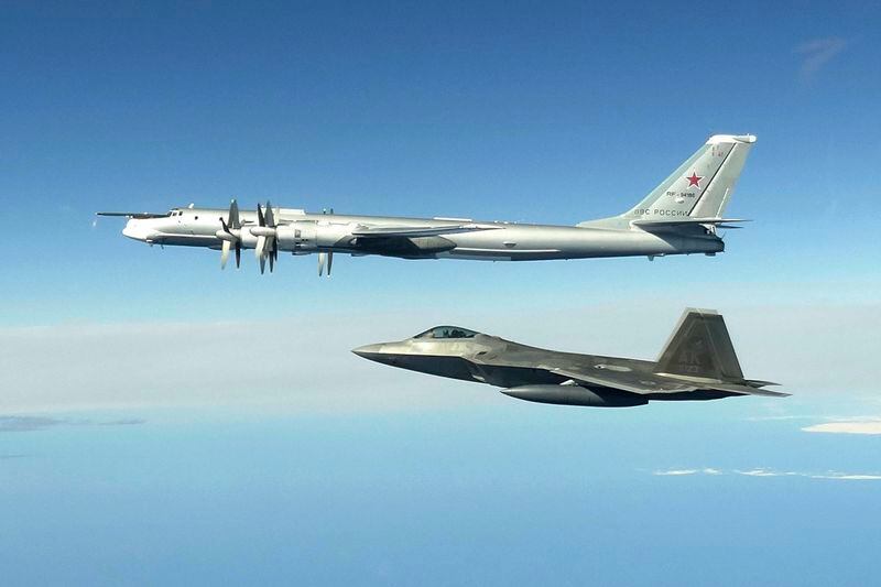 FILE - In this June 16, 2020, image released by the North American Aerospace Defense Command, a Russian Tu-95 bomber, top, is intercepted by a U.S. F-22 Raptor fighter off the coast of Alaska. Personnel changes proposed to take effect Oct. 1, 2024, at the national level may hinder the Alaska Air National Guard's ability to refuel U.S. and Canadian fighter jets when they scramble to escort Russian bombers nearing North American air space. (North American Aerospace Defense Command via AP)