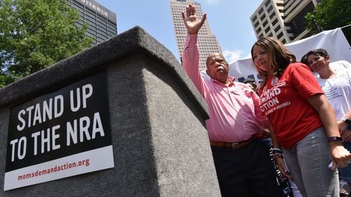 U.S. Rep. John Lewis waves after he spoke to the crowd at a protest Saturday in Woodruff Park. The protest was organized by gun control advocates, who held it blocks away from the National Rifle Association’s annual convention in downtown Atlanta. HYOSUB SHIN / HSHIN@AJC.COM