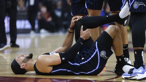 Orlando Magic guard Jalen Suggs holds his knee after being injured during the first half of Game 2 of an NBA basketball first-round playoff series against the Cleveland Cavaliers, Monday, April 22, 2024, in Cleveland. (AP Photo/Ron Schwane)
