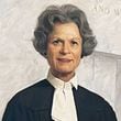 Georgia Court of Appeals Judge Dorothy Toth Beasley, the court's first female judge and female chief judge, stands in front of the court's motto – to which she added the words "and women" – in her official portrait. Beasley, who died May 19, was Georgia's first female appellate judge.