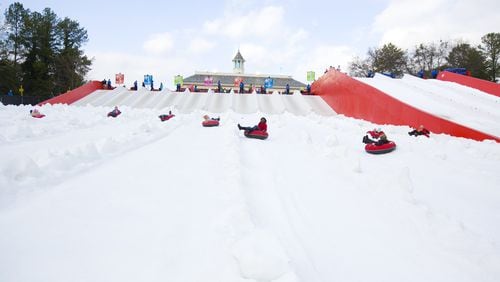 Snow Mountain visitors are seen here tubing on the fake stuff at Stone Mountain Park. The park could be in store for the real thing this weekend.