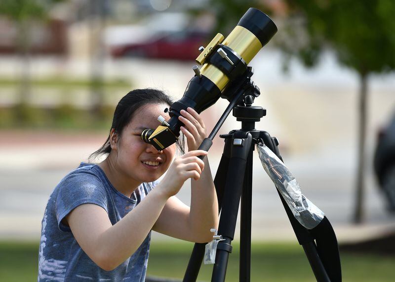 Stephanie Yates tries to spot Mercury crossing the Sun during an Advantage Point Education astronomy class in Sugar Hill. BRANT SANDERLIN/BSANDERLIN@AJC.COM