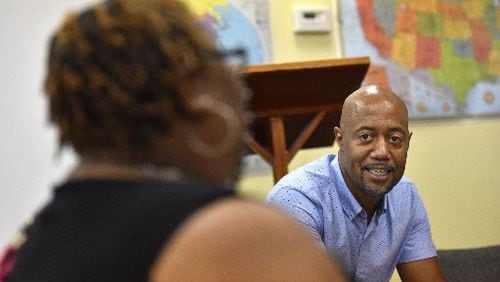 Craig Washington (background) leads a discussion about being a long-time HIV survivor during a weekend summit in July. HYOSUB SHIN / HSHIN@AJC.COM