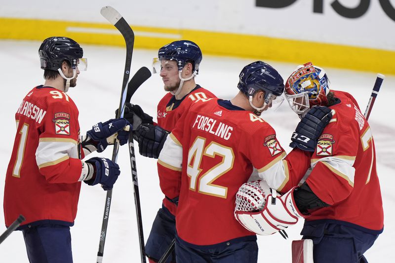 Florida Panthers players congratulate each other after the Panthers beat the Tampa Bay Lightning 3-2, during Game 1 of the first-round of an NHL Stanley Cup Playoff series, Sunday, April 21, 2024, in Sunrise, Fla. (AP Photo/Wilfredo Lee)