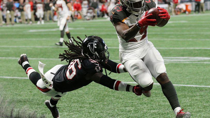 Buccaneers running back Peyton Barber gets past Falcons safety Kemal Ishmael for a touchdown during the third quarter in a NFL football game on Sunday, November 26, 2017, in Atlanta.