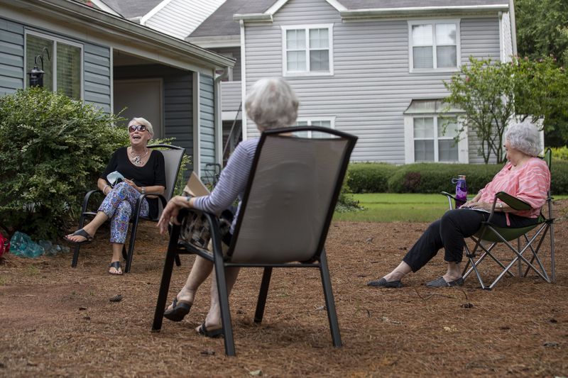  Peggy Burgess (left) laughs while sharing a story with Anjo Jones (right) and Christena Bledose (center) as they socially distance at a neighbor's backyard in Avondale Estates. (ALYSSA POINTER / ALYSSA.POINTER@AJC.COM)