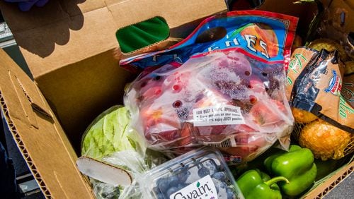 DeKalb County gave away bags of frozen chicken and boxes of fresh produce on May 22.  (Jenni Girtman for Atlanta Journal Constitution)