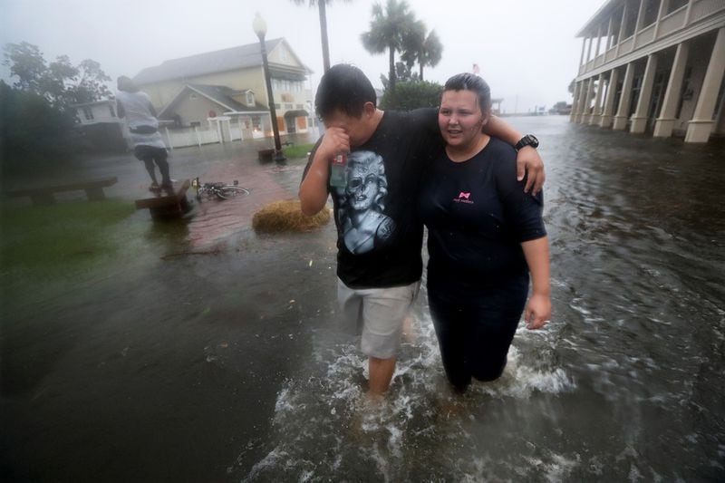 Michael & Tori Munton make their way through the flooded streets of downtown historic St. Marys as the storm surge from Hurricane Matthew hits on Friday, Oct. 7, 2016. Fire and Police units have been pulled back until the winds die down. Curtis Compton /ccompton@ajc.com