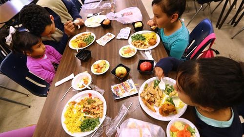 Mohamed Najib and his daughters Park (clockwise from left), 5, Maria, 7, and Luila, 8, have lunch during spring break at Indian Creek Elementary School on Tuesday, April 2, 2019, in Clarkston. CURTIS COMPTON/CCOMPTON@AJC.COM