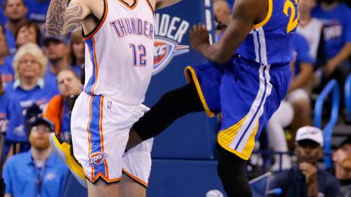 Golden State's Draymond Green's delivers a shot between the legs of Oklahoma City's Steven Adams during Game 3 of the NBA's Western Conference finals Sunday night. (AP photo)
