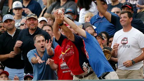 Fans reach for a foul ball during the Braves-Diamondbacks game on Saturday. (AP Photo/John Bazemore)
