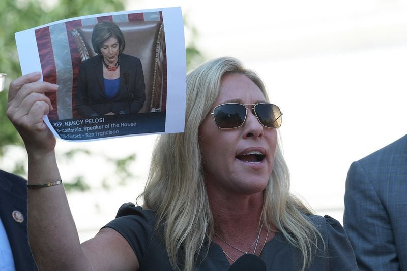 U.S. Rep. Marjorie Taylor Greene of Rome, shown holding a photo of House Speaker Nancy Pelosi, is one of three Republican members of the House suing Pelosi over fines they received for not complying with a mask mandate to stem the spread of the coronavirus. (Lenin Nolly/ZUMA Press Wire/TNS)