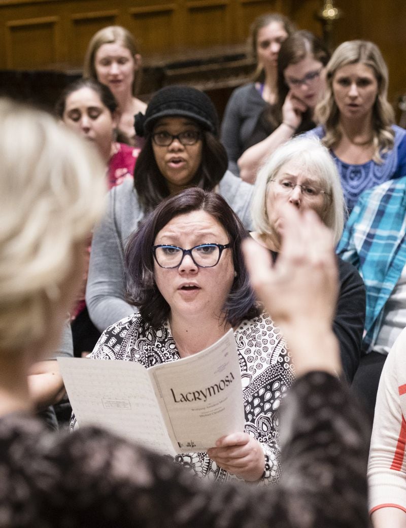 Director Melissa Arasi (back to camera) leads the Atlanta Women’s Chorus as members including Ella Doyle (front) rehearse for next month’s anniversary show, “Rewind: The First Five Years.” JOHN AMIS / SPECIAL