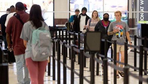 Passengers stand in line waiting to pass through security Sunday at Hartsfield-Jackson Atlanta International Airport on May 3, 2020. STEVE SCHAEFER / SPECIAL TO THE AJC