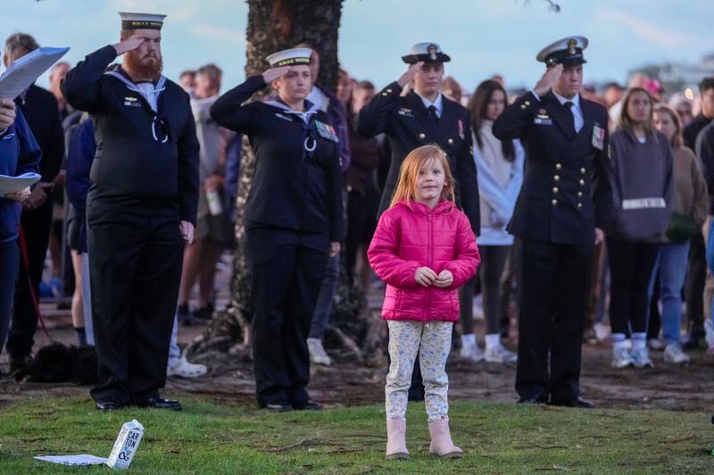 A young girl reacts during an Anzac Day dawn service at Coogee Beach in Sydney, Australia, Thursday, April 25, 2024. (AP Photo/Mark Baker)