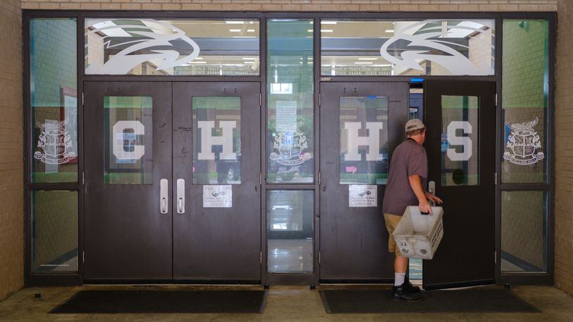 A person enters Collins Hill High School in Suwanee on July 22, 2022. The school is equipped with a vestibule entrance that adds a layer of security. The district plans to install vestibules at all schools by the end of 2023. (Arvin Temkar / arvin.temkar@ajc.com)