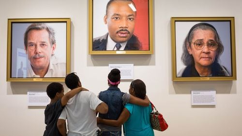 Visitors to the National Center for Civil and Human Rights look at a portrait of Martin Luther King Jr. A new exhibit of artifacts from the Morehouse collection of King’s papers will go on display this weekend at the center, in time for the King Holiday. CONTRIBUTED: NATIONAL CENTER FOR CIVIL AND HUMAN RIGHTS