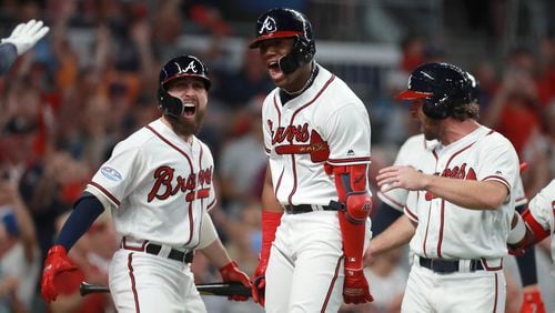 Atlanta Braves left fielder Ronald Acuna reacts after hitting a grand slam home run with center fielder Ender Inciarte, left, in the second inning against the Los Angeles Dodgers in Game 3 of a National League Division Series baseball game Sunday, October 7, 2018, in Atlanta. Curtis Compton/ccompton@ajc.com