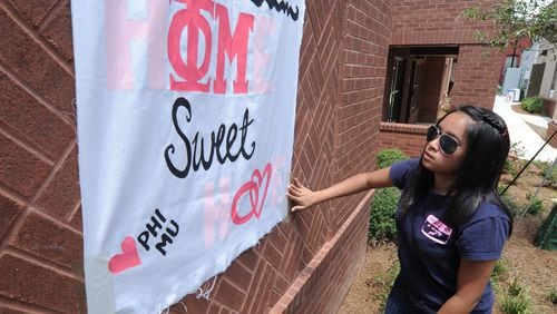 100812- Atlanta - Umama Kibria puts up a welcome sign for her Phi Mu sisters on Thursday AUG 12, 2010. Students moved into the new Special Interest Student House at Georgia State today. This is the Greek housing for the frats and sororities. It is nine three-story town homes with 139 beds at the corner of Edgewood and Piedmont. Nine of the 24 Greek organizations are moving in. The sororities that will live in Greek Housing this year are Alpha Omicron Pi, Alpha Xi Delta, Delta Zeta, Phi Mu and Zeta Tau Alpha. The fraternities are Kappa Sigma, Phi Beta Sigma, Pi Kappa Phi and Sigma Nu. JohnnyCrawford,Jcrawford@ajc.com