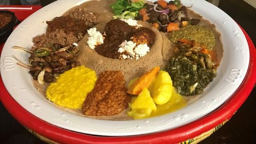 The Ghion Cultural Platter is a good way to sample a variety of Ethiopian dishes at Ghion Cultural Hall. The platter includes multiple lentil dishes, cooked vegetables, dry tibs (sauteed lamb or beef cubes), awaze tibs (tibs seasoned with a spicy sauce made from a blend of berbere, paprika and other spices), and doro wot (stewed chicken), all set atop spongy injera bread. The injera bread is used instead of utensils for scooping up the food. LIGAYA FIGUERAS / LFIGUERAS@AJC.COM