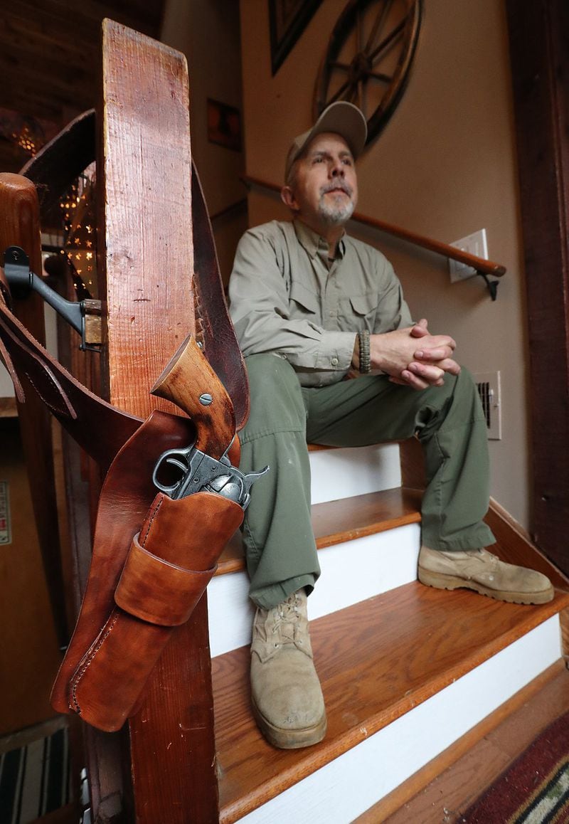 A gun and holster, actually a toy replica, hangs as decor on the bannister by the front door of Ronny West, a Second Amendment advocate and Trump supporter. Curtis Compton/ccompton@ajc.com