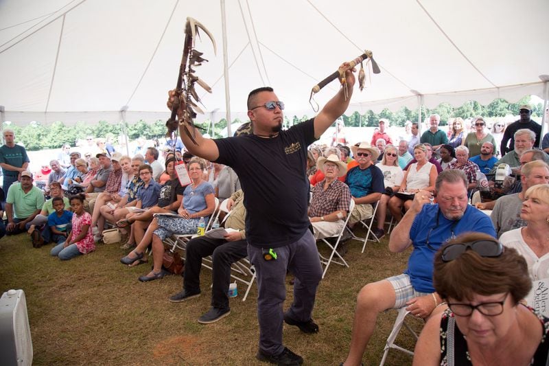 Juan Carlos holds up an item that is being auctioned off  at the  85-acre McIver ranch  before the start of the auction Aug. 4, 2018. (Photo: STEVE SCHAEFER / SPECIAL TO THE AJC)