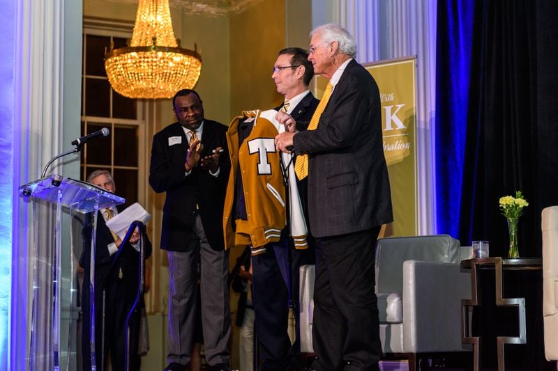 Georgia Tech great Jack Thompson (right), a former Tech assistant football coach and administrator credited with raising nearly $600 million for Tech athletics purposes, receives a Tech letter jacket from athletic director Todd Stansbury (center) and Tech football legend Lucius Sanford at a dinner in 2018 honoring Thompson for his 50 years of service to Tech athletics. Thompson died July 21, 2021. (Photo by Danny Karnik/Georgia Tech Athletics)