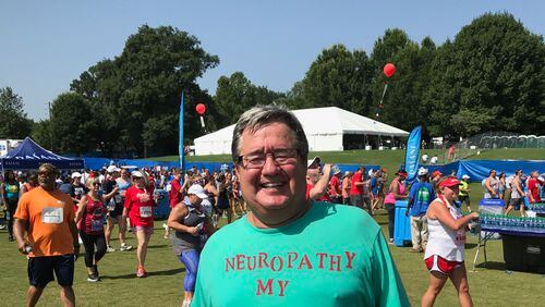 Jim Jochum proudly shows his shirt after completing AJC Peachtree Road Race.