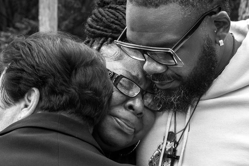 Adrian Johnson (center) mourns her husband Marcus before his viewing.  