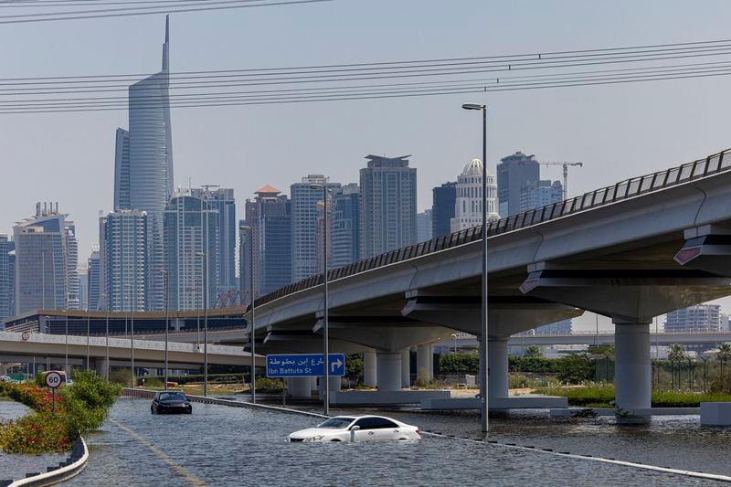 Abandoned vehicles stand in floodwater caused by heavy rain along Sheikh Zayed Road highway in Dubai, United Arab Emirates, Thursday, April 18, 2024. The United Arab Emirates attempted to dry out Thursday from the heaviest rain the desert nation has ever recorded, a deluge that flooded out Dubai International Airport and disrupted flights through the world's busiest airfield for international travel. (AP Photo/Christopher Pike)