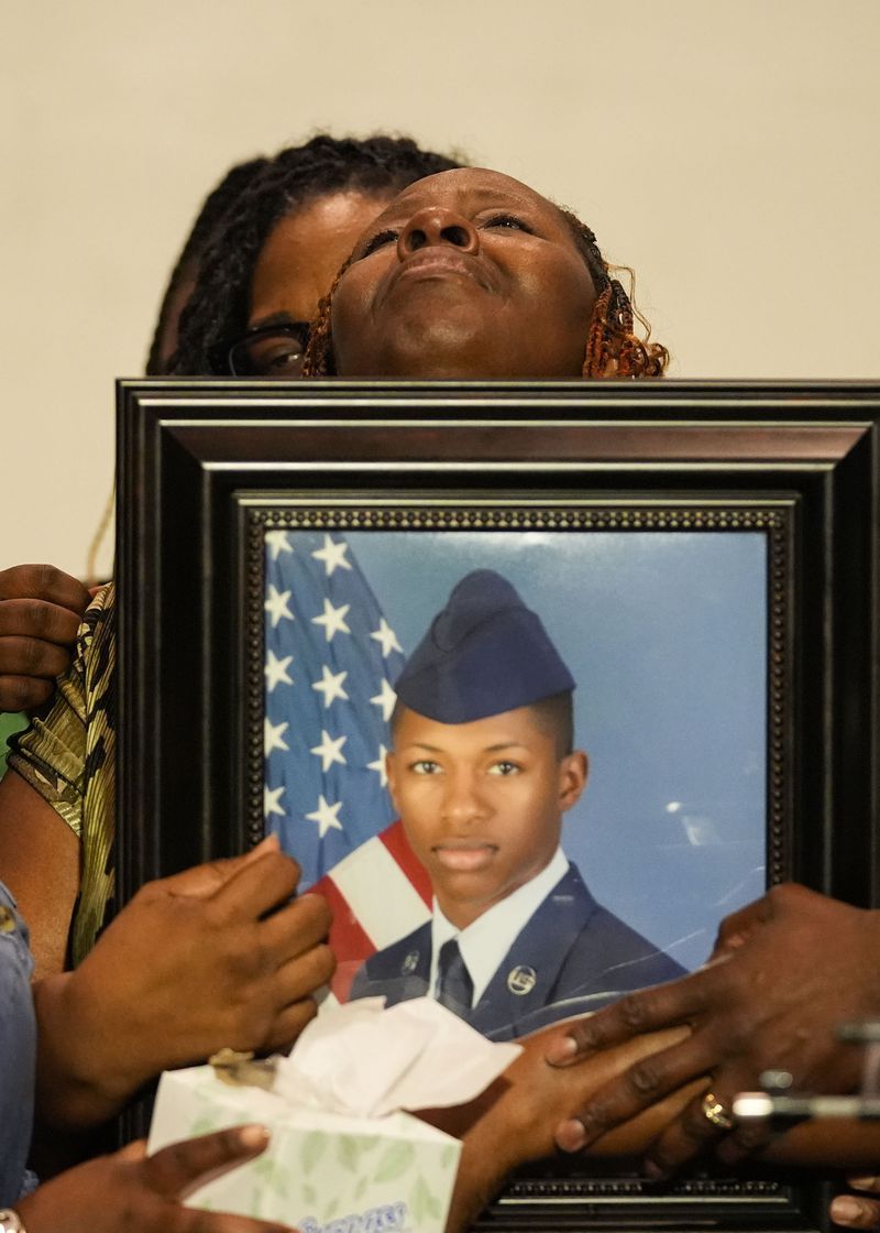 Chantimekki Fortson, mother of Roger Fortson, a U.S. Navy airman, weeps as she holds a photo of her son during a news conference regarding his death, along with family and Attorney Ben Crump, Thursday, May 9, 2024, in Ft. Walton Beach, Fla. Fortson was shot and killed by police in his apartment on May 3, 2024. (AP Photo/Gerald Herbert)