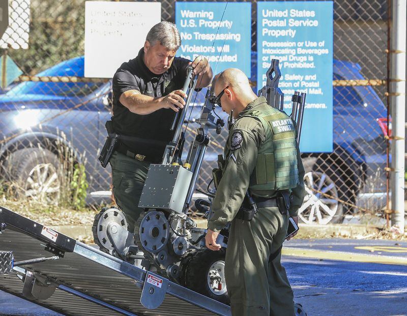 October 29, 2018 Atlanta: Atlanta police bomb squad members roll a robot back onto their truck after removing a suspicious package from a post office at 400 Pryor Street on Monday morning. JOHN SPINK/JSPINK@AJC.COM