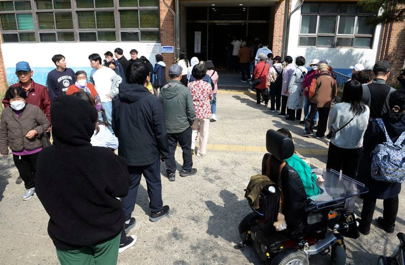 People wait in line to cast their votes for the parliamentary election at a polling station in Ulsan, South Korea, Wednesday, April 10, 2024. South Korean President Yoon Suk Yeol faces a crucial referendum Wednesday in a parliamentary election that could determine whether he becomes a lame duck or enjoys a mandate to pursue key policies for his remaining three years in office. (Bae Byung-soo/Newsis via AP)