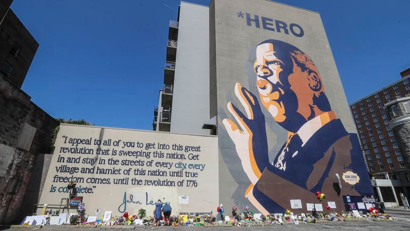 Amanda Hiley and her husband Todd Heifner from Birmingham, Ala., placed flowers and a candle at the John Lewis Mural at Jesse Hill Jr. Drive and Auburn Avenue in Atlanta on Monday, July 20, 2020. She met John Lewis at an Equal Justice Initiative gathering and felt compelled to come to Atlanta and leave flowers. The U.S. House of Representatives convened Monday morning, July 20, 2020, for the first time in more than three decades without John Lewis serving as the conscience of Congress. Lewis, 80, died late Friday, July 17, 2020, after a battle with pancreatic cancer, only hours after another civil rights legend, C.T. Vivian, died at age 95. JOHN SPINK / JSPINK@AJC.COM