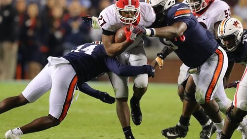 Auburn defenders Stephen Roberts and Derrick Brown sandwich Georgia running back Nick Chubb during a Nov. 11 game. The teams have a rematch Saturday in the SEC Championship game.