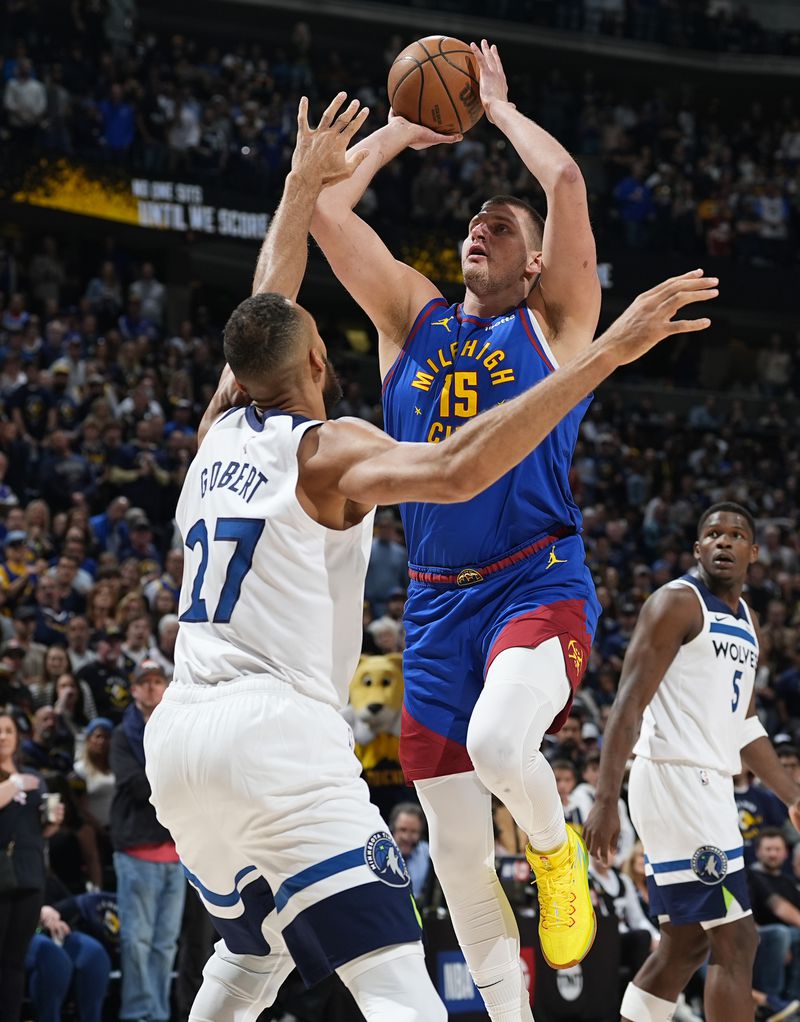 Denver Nuggets center Nikola Jokic, right, goes up for a basket over Minnesota Timberwolves center Rudy Gobert in the first half of an Game 1 of an NBA basketball second-round playoff series Saturday, May 4, 2024, in Denver. (AP Photo/David Zalubowski)