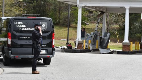 DeKalb County police look over the remains of a drive-thru ATM at the Bank of America along Lawrenceville Highway on March 29. Abdurrahim Jalal was arrested in the incident a month later.